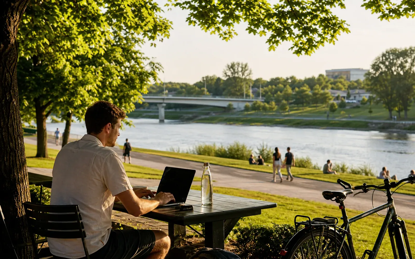 Remote professional working beside the river in Kaunas on a warm summer evening
